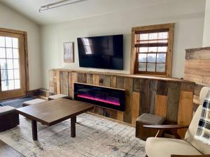 a living room with a fireplace and a flat screen tv at Luxury ADA Unit - 101 in Wilmington