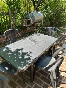 a picnic table with two chairs and a grill at La Luisa in Merlo