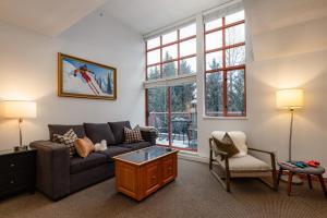 a living room with a couch and a table at Village Penthouse w Views Pool and Hot Tub in Whistler