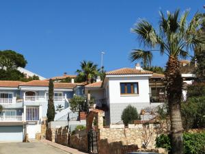 a white house with a fence and palm trees at Los Geraneos in Águilas +12 photos