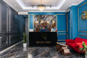 a living room with blue walls and a red couch at Resident Hotel in Tashkent