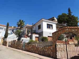 a large white house with a stone fence at Los Geraneos in Águilas