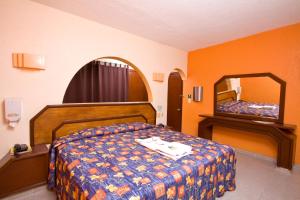 a hotel room with a bed and a mirror at Hotel & Motel Hacienda Jiutepec in Jiutepec +47 photos