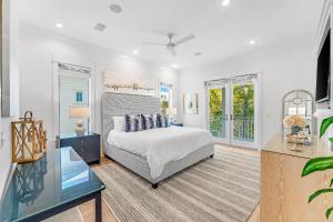 a bedroom with a bed and a desk and windows at Sand On Tap in Inlet Beach +60 photos