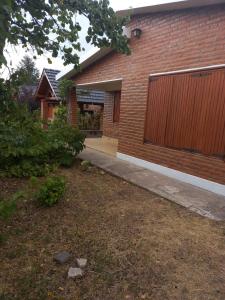 a brick house with a garage and a driveway at La Luisa in Merlo