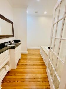 bagno bianco con lavandino e specchio di Emigrant's Inn a Fredericksburg Altre 37 foto