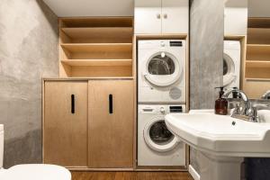 a bathroom with a sink and a washer and dryer at Luxury Loft near Washington Park - Rooftop Deck in Cincinnati