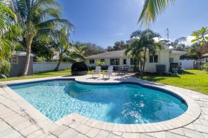 a swimming pool with a patio and a house at NEW Riverside Retreat with Pool in Jupiter