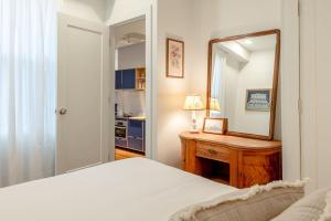 un dormitorio con una cama y un espejo en Walk to ALL - Washington Park - Gorgeous 2BR Condo, en Cincinnati