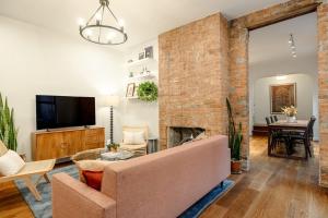 sala de estar con chimenea de ladrillo y sofá en Walk to ALL - Washington Park - Gorgeous 2BR Condo, en Cincinnati