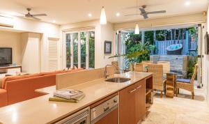 a kitchen and living room with a couch and a table at Courtyard on Murphy Tropical Oasis in Town in Port Douglas