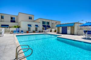 a swimming pool in front of a house at Ocean and Pier View Condo on the Sand in Huntington Beach