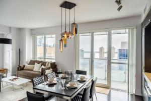 a living room with a table and chairs and a couch at Luxury Condo with Pool, CN Tower View, Gym, Workspace in Toronto