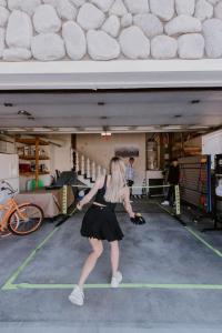 a woman swinging a tennis racket on a tennis court at Stylish Home with Hot Tub, Ping Pong, Pickleball, Electric Scooters and Pet Friendly in Big Bear City