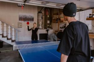 a woman holding a ball in front of a ping pong table at Stylish Home with Hot Tub, Ping Pong, Pickleball, Electric Scooters and Pet Friendly in Big Bear City