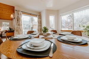 a dining room table with bowls and plates on it at Stylish Home with Hot Tub, Ping Pong, Pickleball, Electric Scooters and Pet Friendly in Big Bear City +24 photos