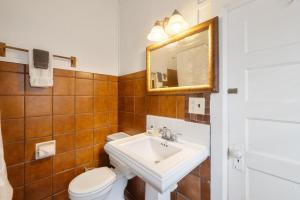 a bathroom with a sink and a toilet and a mirror at Historic Island Hotel in Cedar Key
