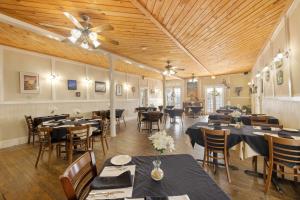 Un restaurante con mesas y sillas y un techo. en Historic Island Hotel, en Cedar Key