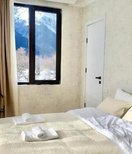 a bedroom with a bed with a view of a mountain at Hillside Mestia ჰილსაიდ მესტია in Mestia