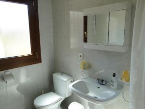 een witte badkamer met een toilet en een wastafel bij Los Geraneos in Águilas