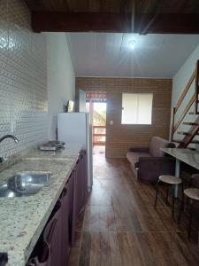a kitchen with a sink and a living room at Casa Descanso dos Amigos in Prado