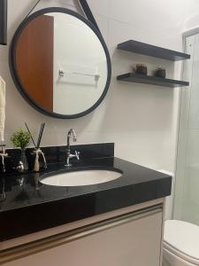 a bathroom with a sink and a mirror at Studio Home in Patrocínio