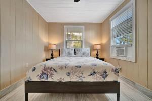 a bedroom with a bed and two lamps and a window at Stones Throw Beachside Bungalow #1 ON THE BEACH in Clearwater Beach