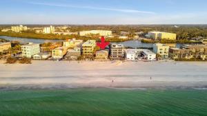 eine Luftansicht auf einen Strand mit Gebäuden und Wasser in der Unterkunft Stones Throw Beachside Bungalow #1 ON THE BEACH in Clearwater Beach