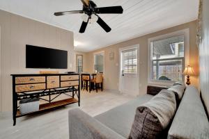 een woonkamer met een bank en een flatscreen-tv bij Stones Throw Beachside Bungalow #1 ON THE BEACH in Clearwater Beach