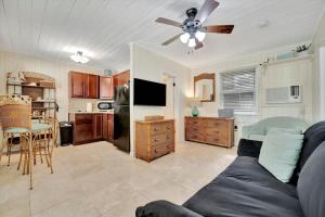 a living room with a couch and a ceiling fan at Stones Throw Beachside Bungalow #2 AT THE BEACH in Clearwater Beach +12 photos