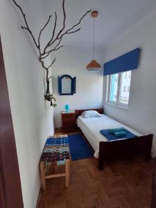 a bedroom with a bed and a tree on the wall at Olive Hostel Lagos in Lagos