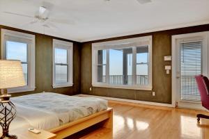 een slaapkamer met een groot bed en ramen bij Stones Throw Beachfront Premier Suite #4 VIEWS in Clearwater Beach