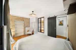 a bedroom with a white bed and a window at Oenosuite - Charme & Vin en hyper-centre in Dijon