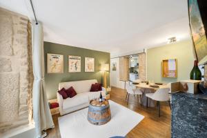 a living room with a couch and a table at Oenosuite - Charme & Vin en hyper-centre in Dijon