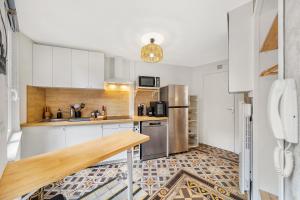 a kitchen with white cabinets and stainless steel appliances at Oenosuite - Charme & Vin en hyper-centre in Dijon