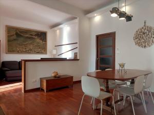 Una sala de estar con mesa de comedor y sillas. en Veranda Liberty, luxury apartment, en La Spezia
