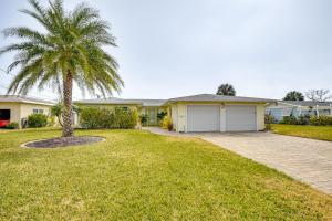 una casa con una palmera y un camino de entrada en Sunny South Daytona Home with Pool and Grill!, en South Daytona