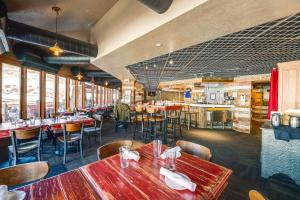 a restaurant with tables and chairs in a room at Ski-InandSki-Out Park City Condo Fireplace and View! in Park City