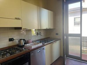 Una cocina con gabinetes blancos, un fregadero y una estufa. en Diamond House, en Virgilio 1 foto más
