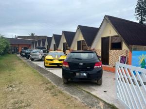 eine Reihe von Autos auf einem Parkplatz in der Unterkunft Chalemar Itanhaém in Itanhaém