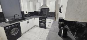 a black and white kitchen with a washing machine at Newly renovated cosy home BB10 in Burnley