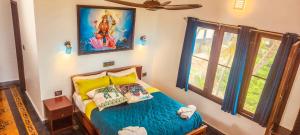 ein Schlafzimmer mit einem Bett und einem Gemälde an der Wand in der Unterkunft Kesaviyam Unique Ocean View Luxury Suites vicinity Kovalam Light house in Kovalam
