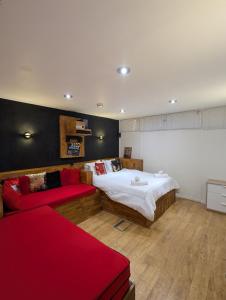 a bedroom with a large bed and a red couch at The Stables at Wits End, Hartford in Hartford