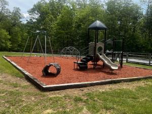 a playground with two swings and a slide at Westcott House- Privacy, amenities and space all in one beautiful package! in Luray +2 photos