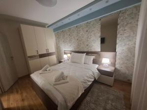 a bedroom with a bed with two towels on it at Astera 2 in Vrnjci
