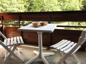 韦尔科尔地区科尔朗松Résidence La Grande Traversee - Charmant studio pied des pistes MAE-3824的门廊上的一张白色桌子和两把椅子