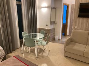 a living room with a glass table and chairs at 4STANZE in Naples