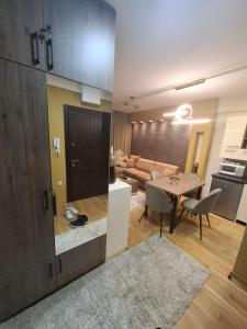 a kitchen and a living room with a table and a couch at Astera 2 in Vrnjci +9 photos