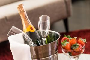a bottle of champagne and a bucket of strawberries at Clarion Collection Hotel Slottsparken in Linköping