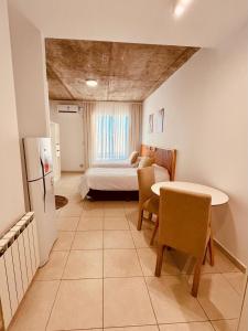 a bedroom with a bed and a table and chairs at Monoambiente Muñíz in Luján